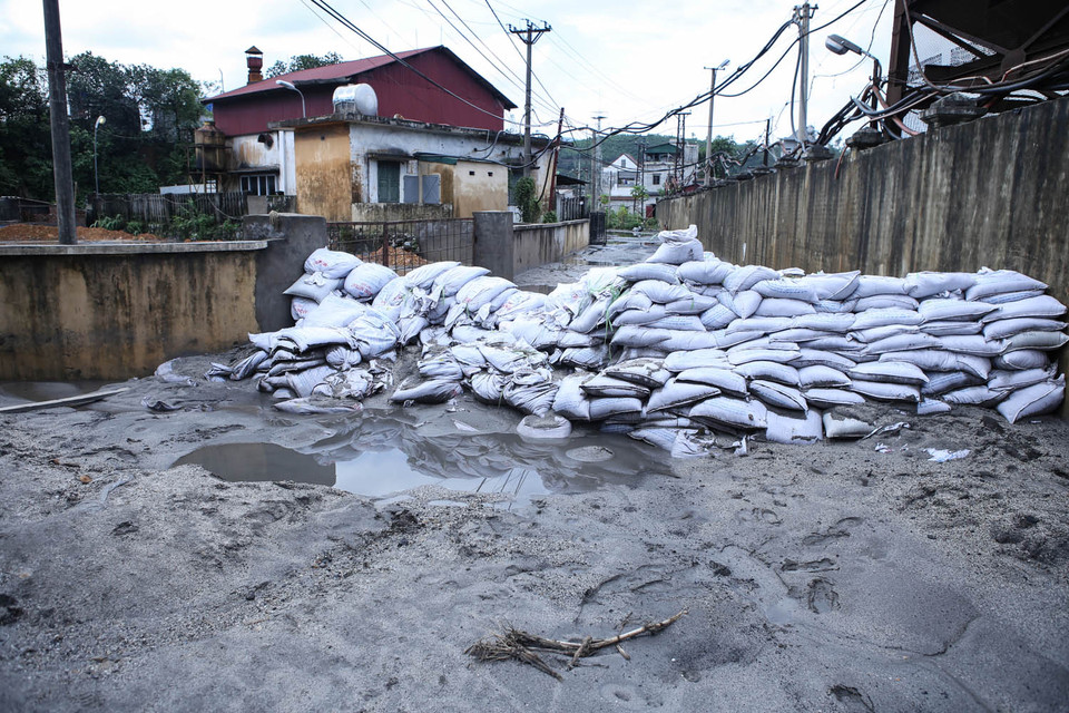 Những bức tường bao cát được dựng lên nhằm ngăn cản những cơn lũ bùn có thể xảy ra bất cứ lúc nào. (Ảnh: PV/Vietnam+)