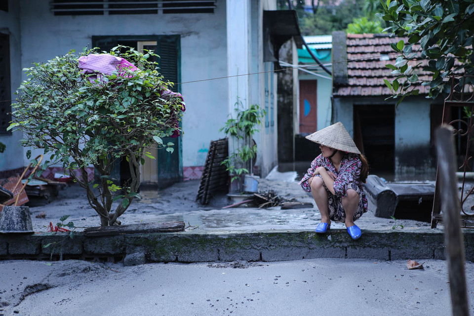  Người phụ nữ thẫn thờ nhìn vào căn nhà dường như không còn là của mình nữa. (Ảnh: PV/Vietnam+)