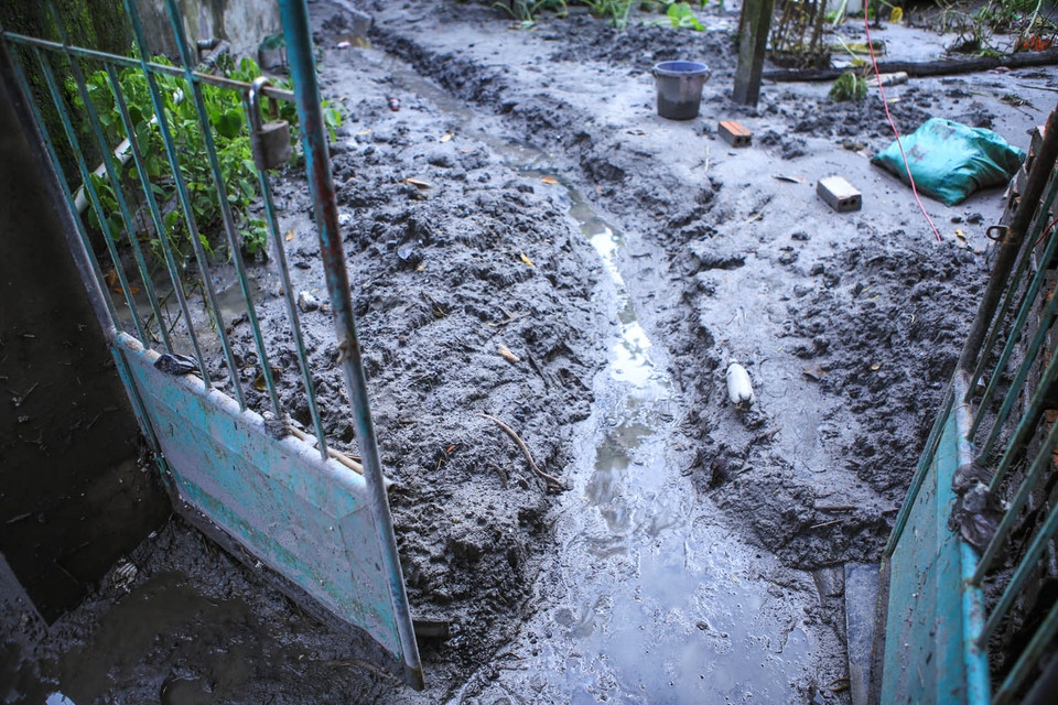 Một số căn nhà đào các rãnh thoát nước để làm bùn đất khô nhanh. (Ảnh: PV/Vietnam+)