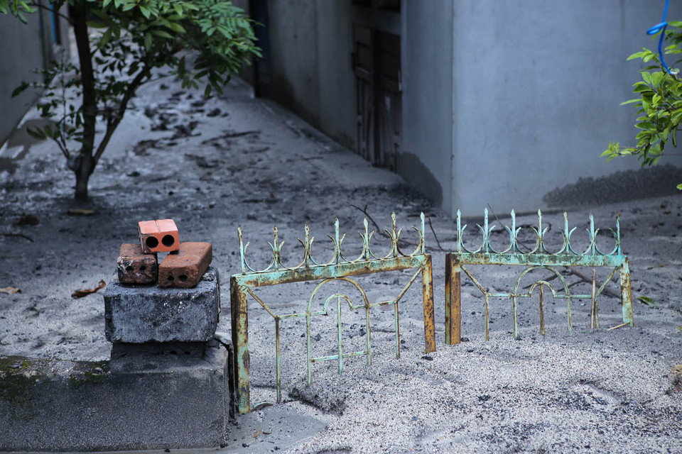 Cổng sắt hoen gỉ không ngăn cản được cơn lũ bùn đổ ập. Gần 100 ngôi nhà thuộc tổ 1, 2 (khu 4, Mông Dương) bị ngập sâu trong bùn. (Ảnh: PV/Vietnam+)