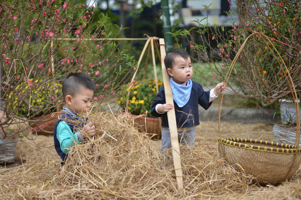 Các em nhỏ lại đặc biệt thích thú khi đùa nghịch với những đống rơm. (Ảnh: PV/Vietnam+)