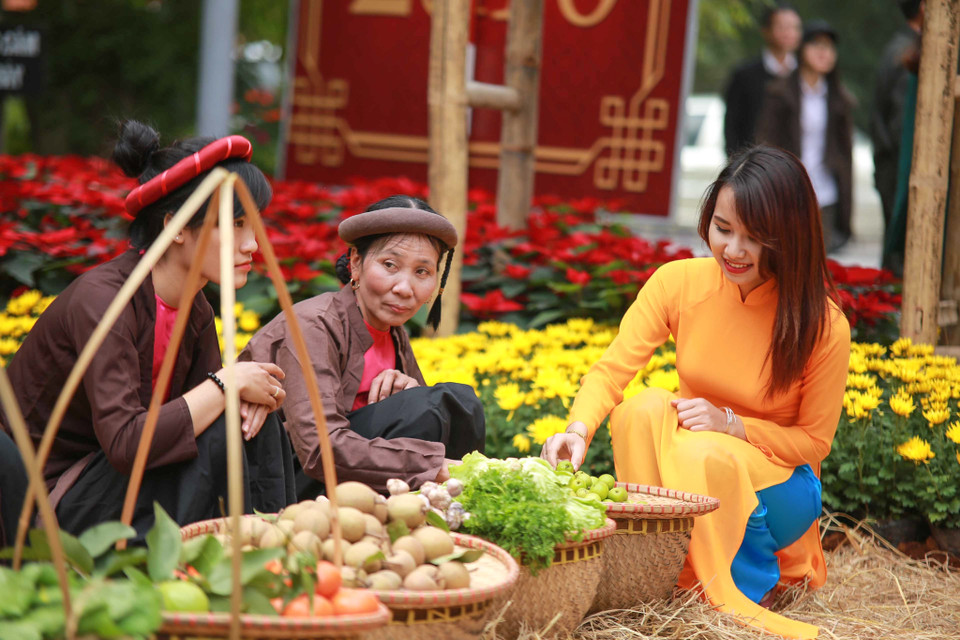 Có đi chợ quê mới cảm nhận được không khí Tết với mưa xuân bay lất phất và dòng người xúng xính áo quần đi chơi. (Ảnh: PV/Vietnam+)