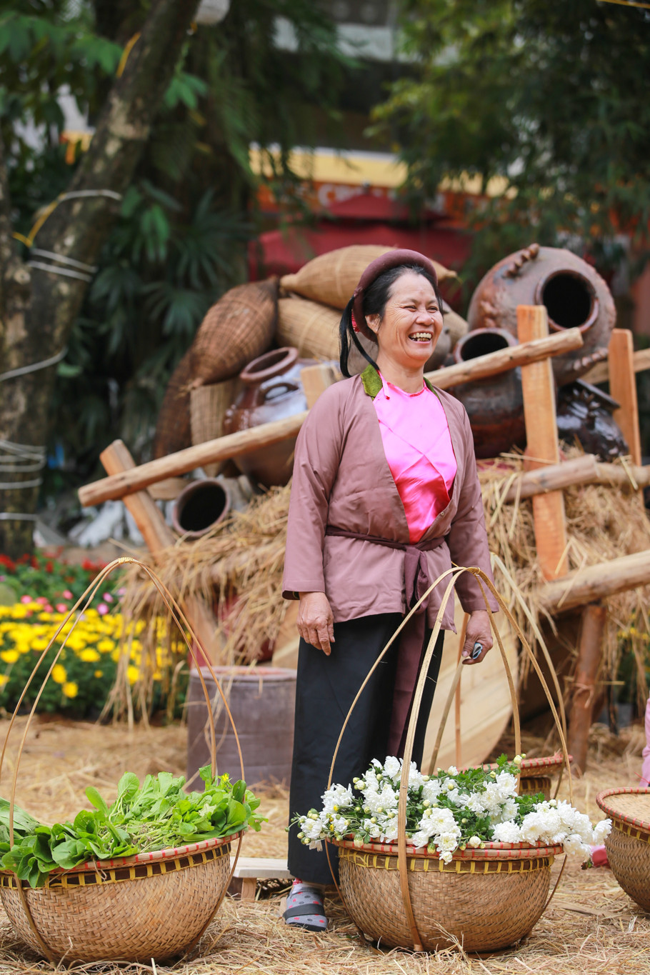 Những cô hàng hoa mớ ba mớ bảy cười rạng rỡ mỗi khi có khách đến mua hàng. (Ảnh: PV/Vietnam+)