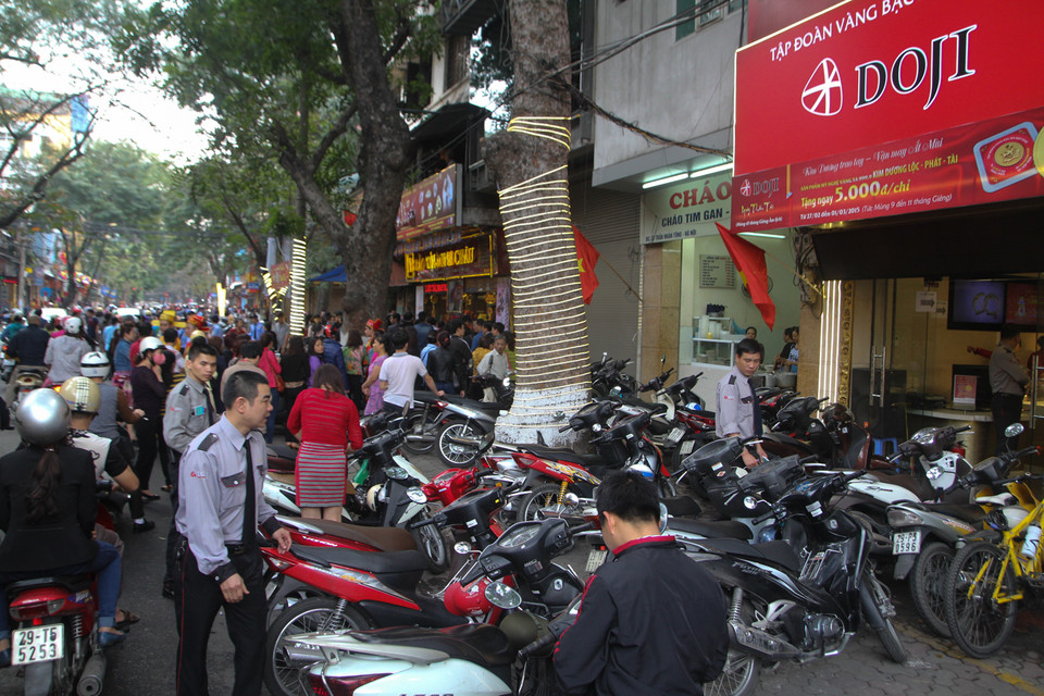 Cận cảnh 2 tiệm vàng sát nhau, 1 tiệm vàng thì thưa thớt, tiệm còn lại đông kín người. (Ảnh: Minh Sơn/Vietnam+)
