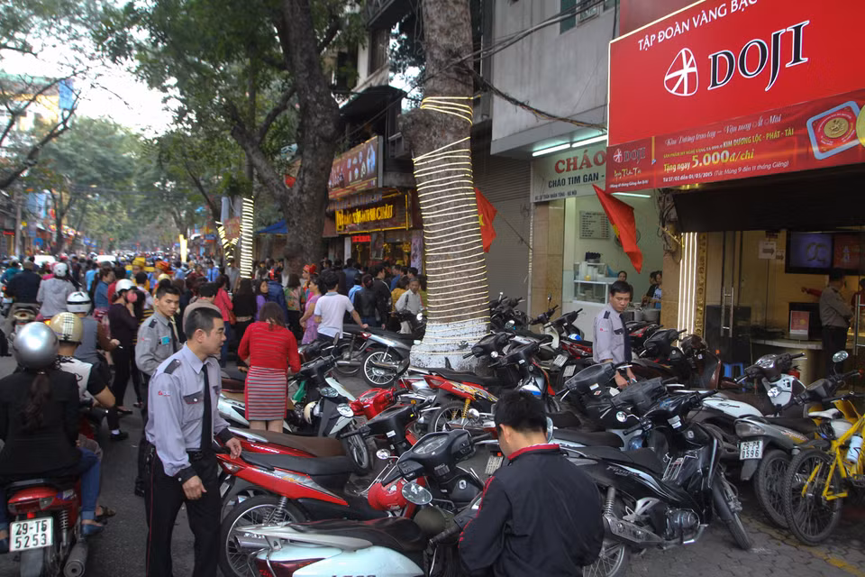 Cận cảnh 2 tiệm vàng sát nhau, 1 tiệm vàng thì thưa thớt, tiệm còn lại đông kín người. (Ảnh: Minh Sơn/Vietnam+)