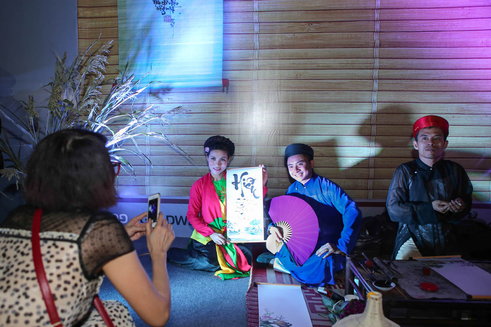 Rất nhiều bạn trẻ cũng muốn đóng vai ông đồ và học cách viết sớ. (Ảnh: PV/Vietnam+)