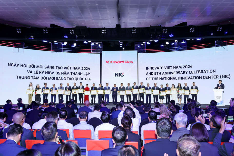 Bộ trưởng Nguyễn Chí Dũng trao bằng khen và kỷ niệm chương cho các cá nhân xuất sắc. (Ảnh: Minh Sơn/Vietnam+)