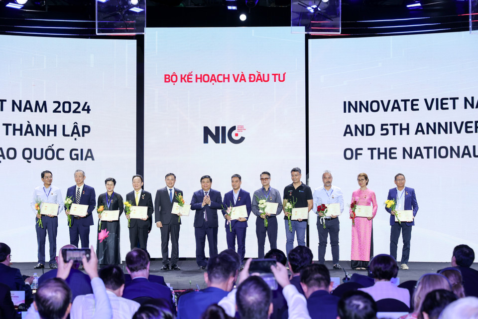 Bộ trưởng Nguyễn Chí Dũng trao bằng khen và kỷ niệm chương cho các đơn vị đồng hành. (Ảnh: Minh Sơn/Vietnam+)