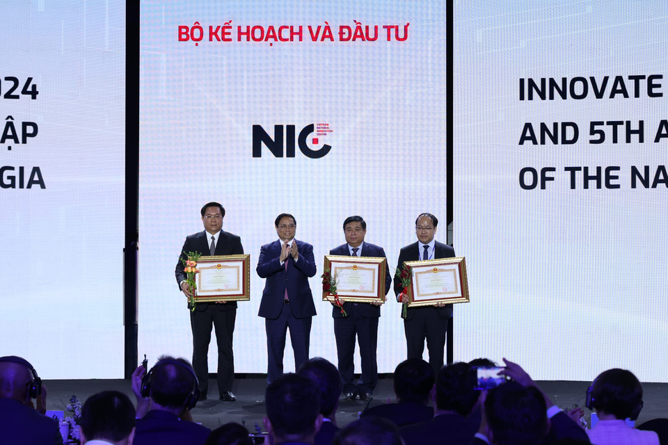 Thủ tướng Phạm Minh Chính trao bằng khen cho lãnh đạo Bộ Kế hoạch và Đầu tư và lãnh đạo NIC. (Ảnh: Minh Sơn/Vietnam+)