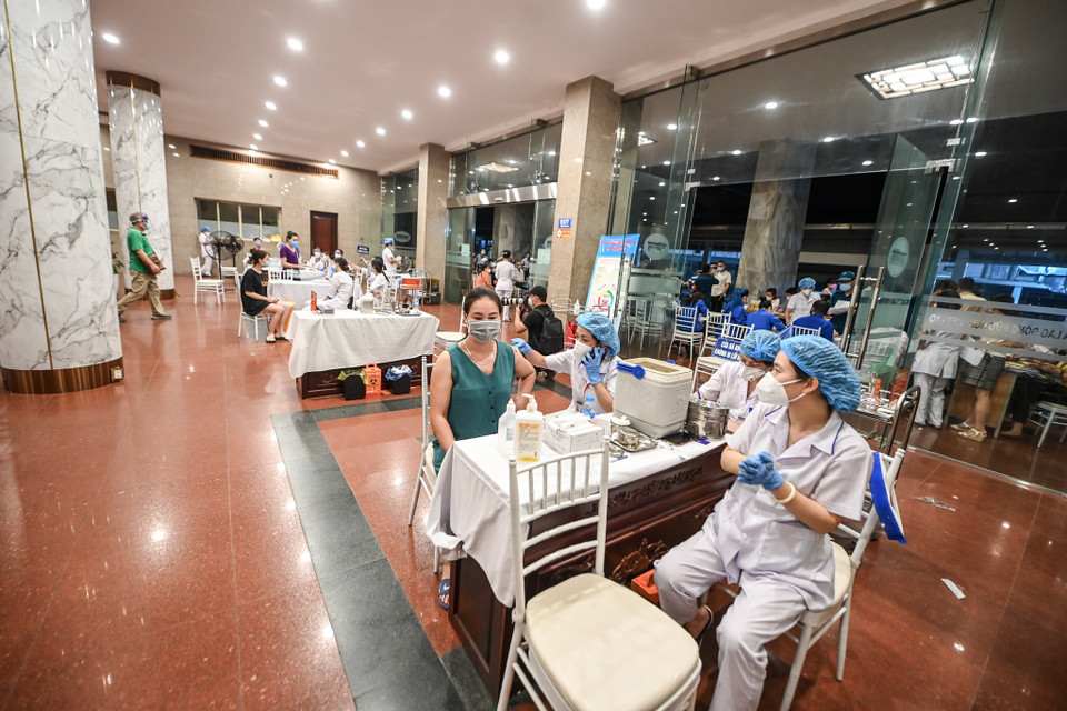 Các bàn tiêm được bố trí giãn cách đảm bảo tiêm chủng an toàn, nhanh chóng, đảm bảo. (Ảnh: PV/Vietnam+)