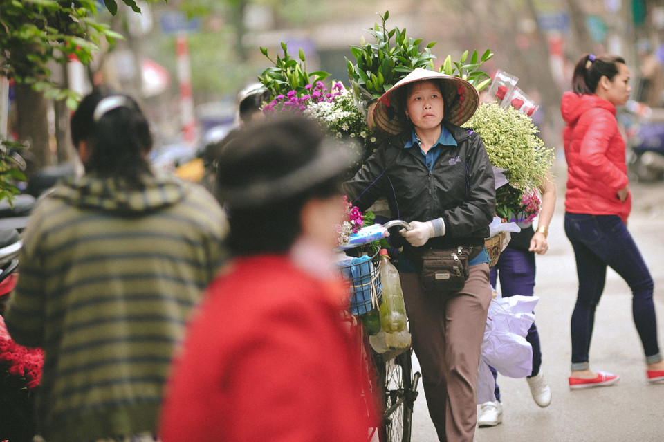 Ngày 8/3 cận kề, những gánh hàng hoa thảnh thơi đi dạo trên phố để chờ khách hàng đón mua. (Ảnh: Minh Sơn/Vietnam+)