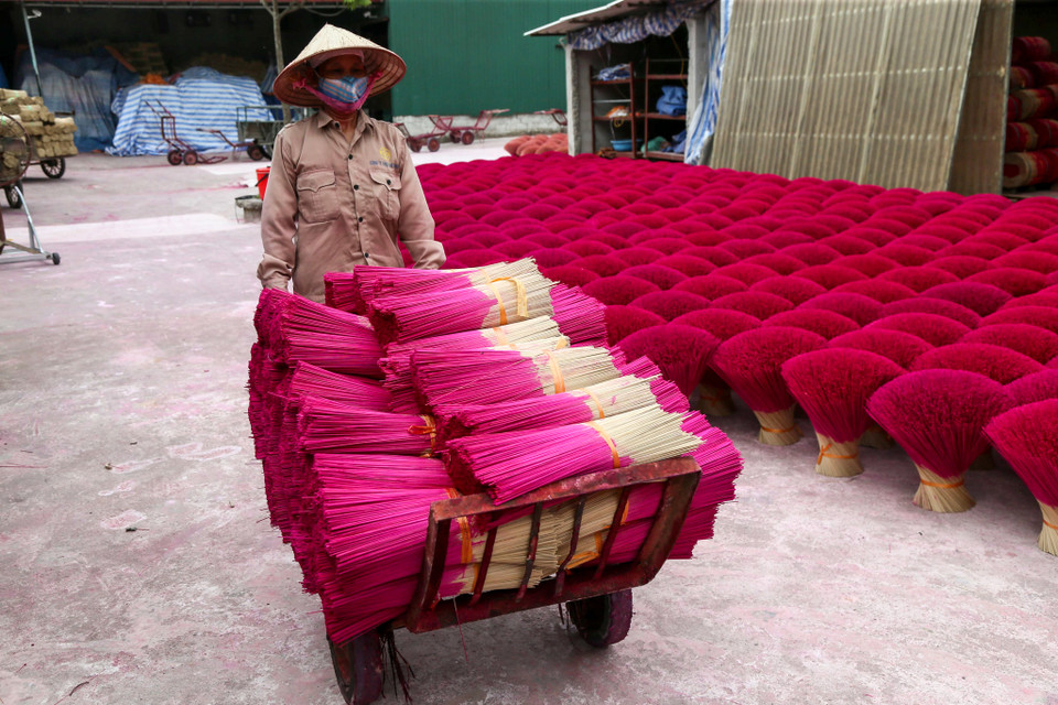 Người dân nơi đây người thì ngồi bổ vầu, người thì đứng máy, học lái xe để vận chuyển nguyên liệu, thành phẩm... (Ảnh: Vietnam+)