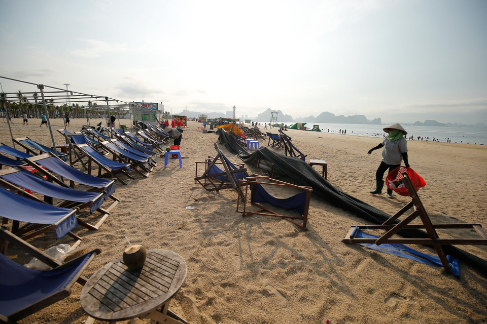 Dù mỗi ngày chịu tới 6 tấn rác thải nhưng chỉ sau một đêm, 4km bờ biển Bãi Cháy (Quảng Ninh) lại trở nên sạch đẹp, trắng tinh phơi mình đón nắng… Đó là nhờ công sức cần mẫn của đội nữ công nhân vệ sinh môi trường. (Ảnh: Vietnam+)