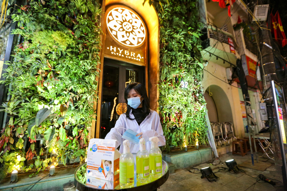 Theo ghi nhận, rất nhiều quán bar, pub trên khu vực phố cổ đã thực hiện nghiêm túc việc phòng chống dịch cho khách hàng như yêu cầu đeo khẩu trang, sát khuẩn tay trước khi vào. (Ảnh: Minh Sơn/Vietnam+)