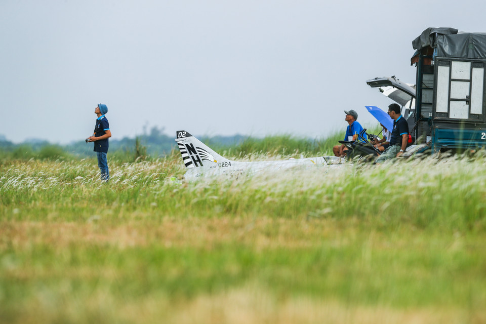Cứ mỗi sáng Chủ Nhật hàng tuần, những người chơi máy bay mô hình lại tập hợp tại khu đất được cấp phép để biểu diễn những pha nhào lộn thót tim. (Ảnh: PV/Vietnam+)
