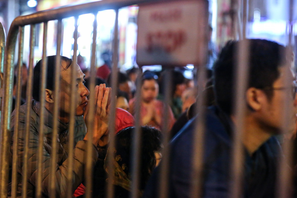 Từ khoảng 18 giờ tối, rất đông người dân đã tập trung trước cổng chùa để làm lễ. Lực lượng chức năng quây hàng rào để đảm bảo giao thông khu vực cầu vượt Ngã Tư Sở. (Ảnh: Minh Sơn/Vietnam+)