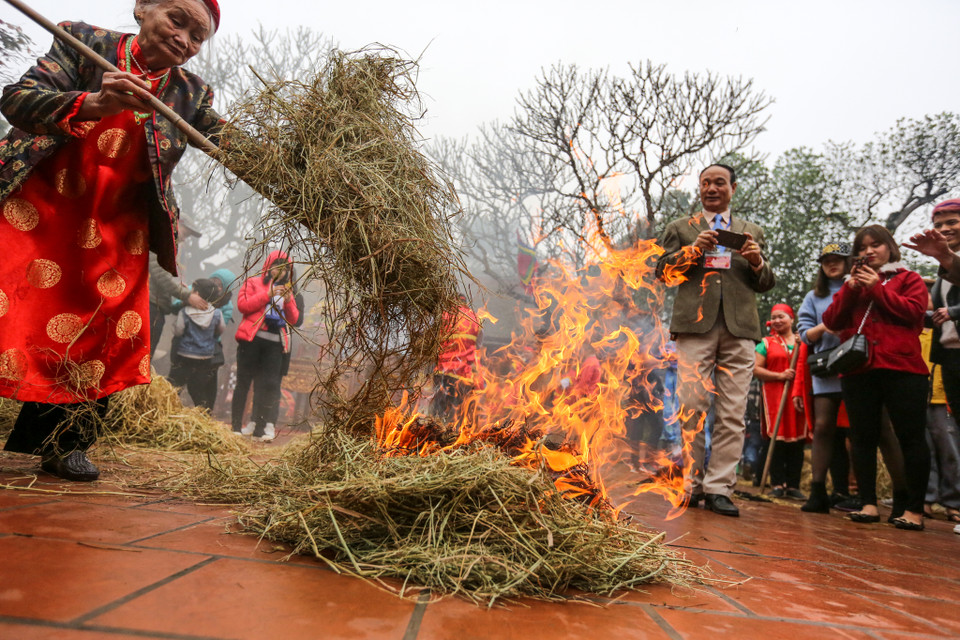 Sân đình sẽ được thui bởi nhiều lớp rơm rạ để các đội mang nồi cơm ra ủ. (Ảnh: Minh Sơn/Vietnam+)