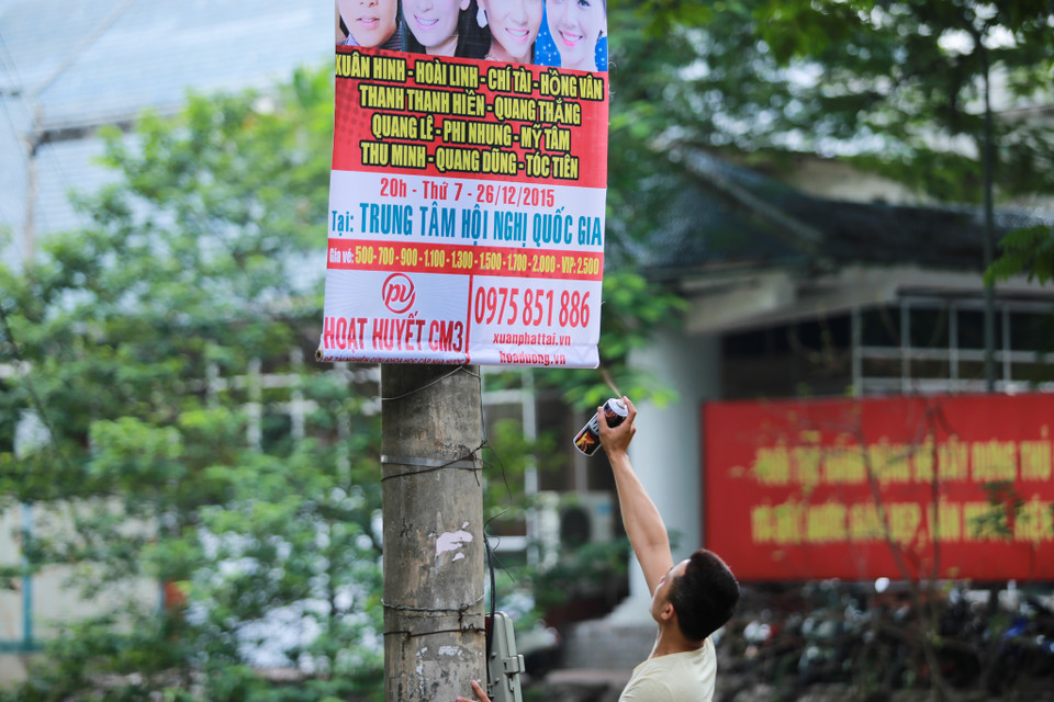 Nhiều đơn vị chưa được giấy phép hoạt động, đã liều treo ‘nhờ’ băng rôn ở các cột điện, gốc cây ảnh hưởng đến mỹ quan đô thị. (Ảnh: Minh Sơn/Vietnam+)