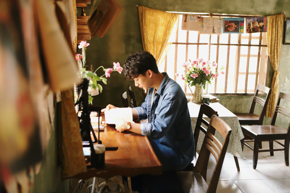 Bên trong, không gian được trang trí đơn giản nhưng ấm cúng với bàn ghế bằng gỗ và những bức thư cổ trên tường. (Ảnh: Quỳnh Anh/Vietnam+)