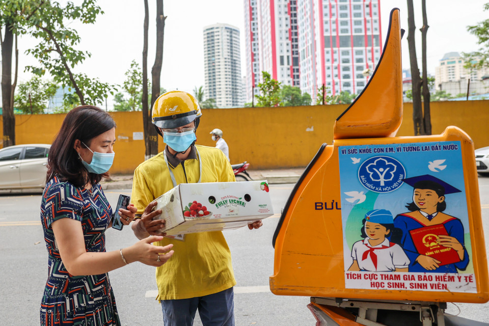 Chị Đặng Thị Vinh (Cầu Giấy, Hà Nội) vui mừng khi nhận gói hàng là 5 cân vải từ Bắc Giang. Toàn bộ các khách hàng sẽ được kiểm tra chất lượng sản phẩm trước khi được bàn giao. (Ảnh: Minh Sơn/Vietnam+)