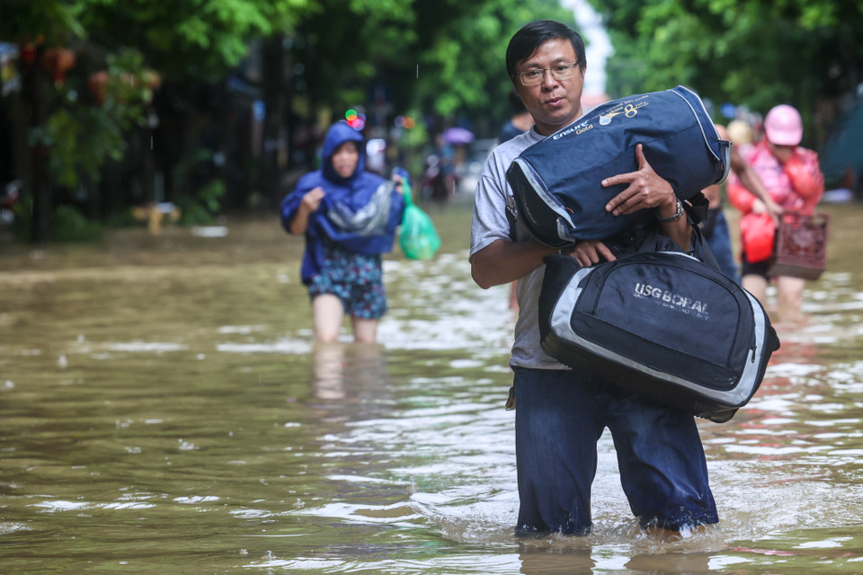 Nhiều hộ dân chạy đua với thời gian, cố gắng vận chuyển càng nhiều đồ đạc ra khỏi nơi ở càng tốt. (Ảnh: Minh Sơn/Vietnam+)