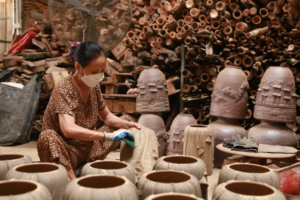 Công đoạn cuối cùng để đưa sản phẩm ra thị trường - chuốt gốm. (Ảnh: PV/Vietnam+)