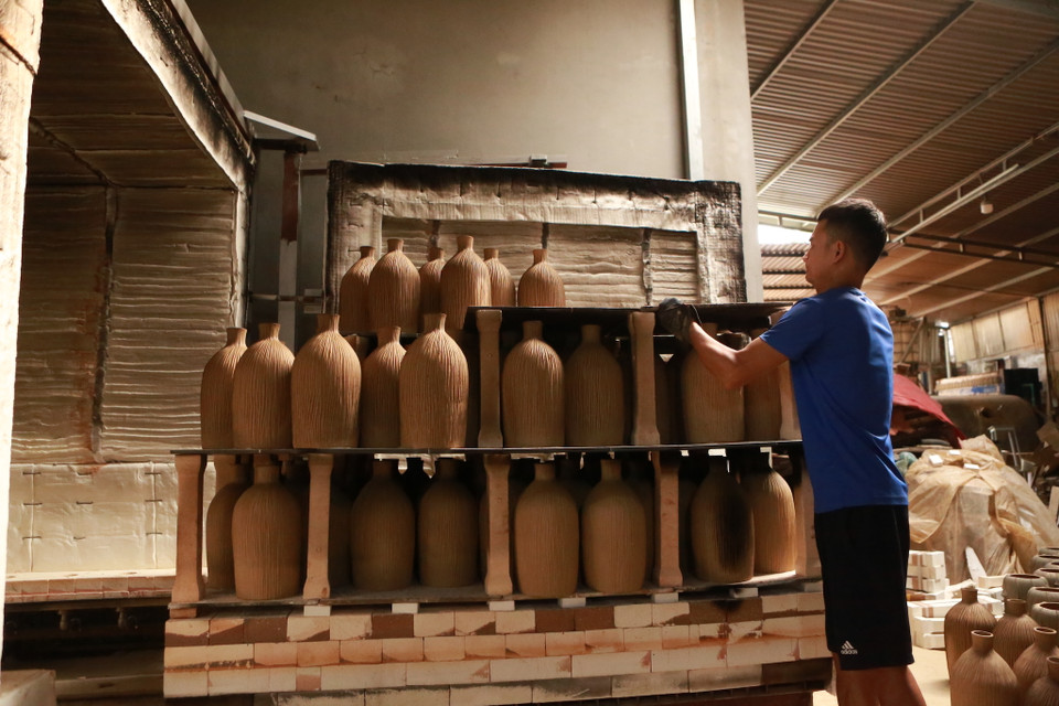 Sau khi hoàn tất trang trí và phơi nắng, người ta sẽ để sản phẩm lên lò nung ở nhiệt độ cao. Đến chặng vào lò thì ở một vài điểm, dưới tác động của nhiệt đốt thủ công sẽ tạo nên màu hỏa biến cho sản phẩm, để khi ra đời, gốm trở thành độc bản. (Ảnh: PV/Vietnam+)