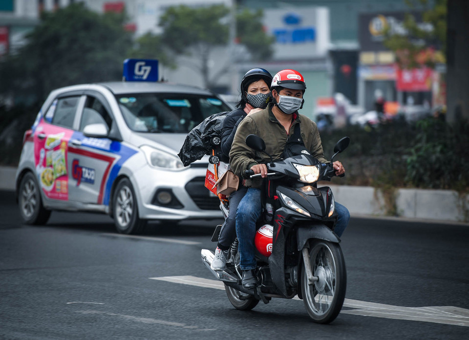 Cảnh tượng người dân nai nịt gọn gàng trên xe máy rời khỏi Thủ đô không phải là hiếm trong mỗi dịp cận Tết. (Ảnh: PV/Vietnam+)