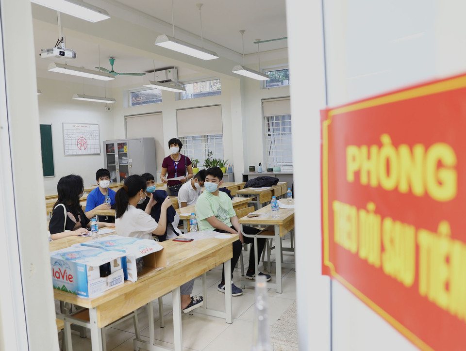 Tại phòng theo dõi sau tiêm các em học sinh được phụ huynh và giáo viên hướng dẫn, nhắc nhở đảm bảo giãn cách. (Ảnh: Hoài Nam/Vietnam+)