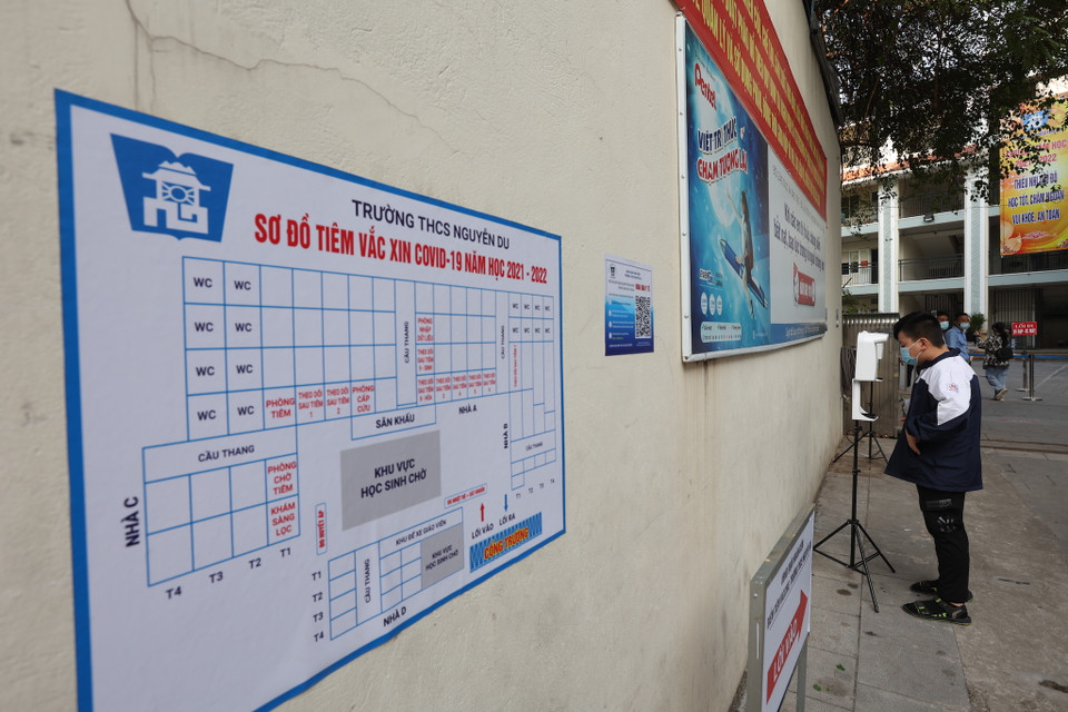 Ngoài việc phải khai báo y tế tại nhà, đến đây các học sinh được đo nhiệt đô, sát khuẩn tay đồng thời quét mã QR. (Ảnh: Hoài Nam/Vietnam+)