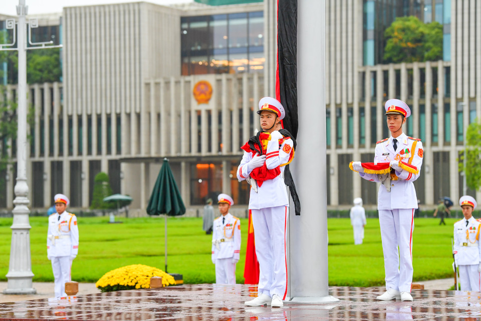 Quốc kỳ buộc dải băng đen được kéo lên trong tiếng nhạc Quốc ca. (Ảnh: Minh Sơn/Vietnam+)