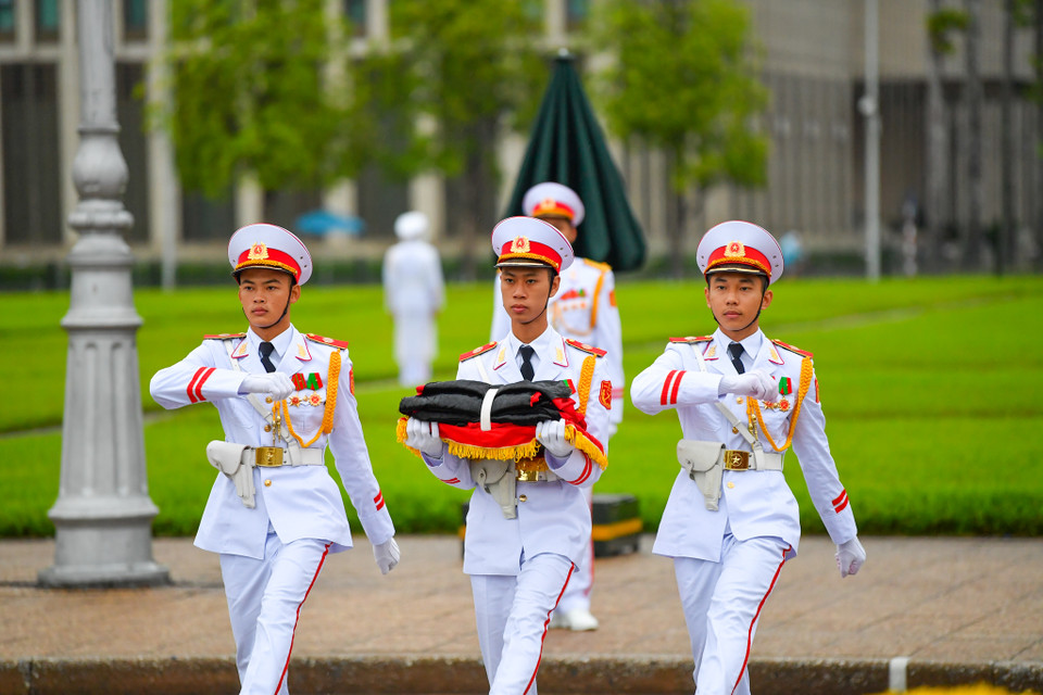 Nghi lễ treo băng tang được tiến hành song song với nghi thức chào cờ hàng ngày vẫn diễn ra trên Quảng trường Ba Đình. (Ảnh: Minh Sơn/Vietnam+)