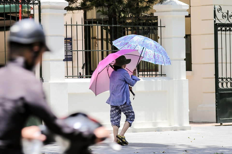 Một cách chống nắng nóng hiệu quả của người dân Thủ đô. (Ảnh: PV/Vietnam+)