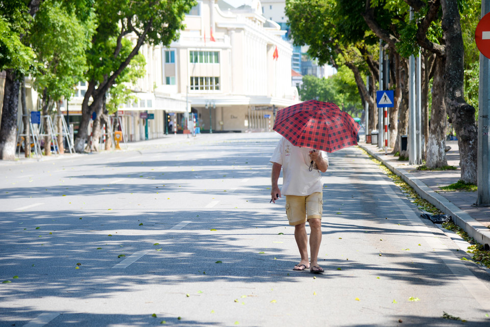 Đi ngoài đường, cảm giác như bị 'thiêu đốt trên chảo lửa' khi hơi nóng từ mặt đường nhựa phả lên. (Ảnh: PV/Vietnam+)