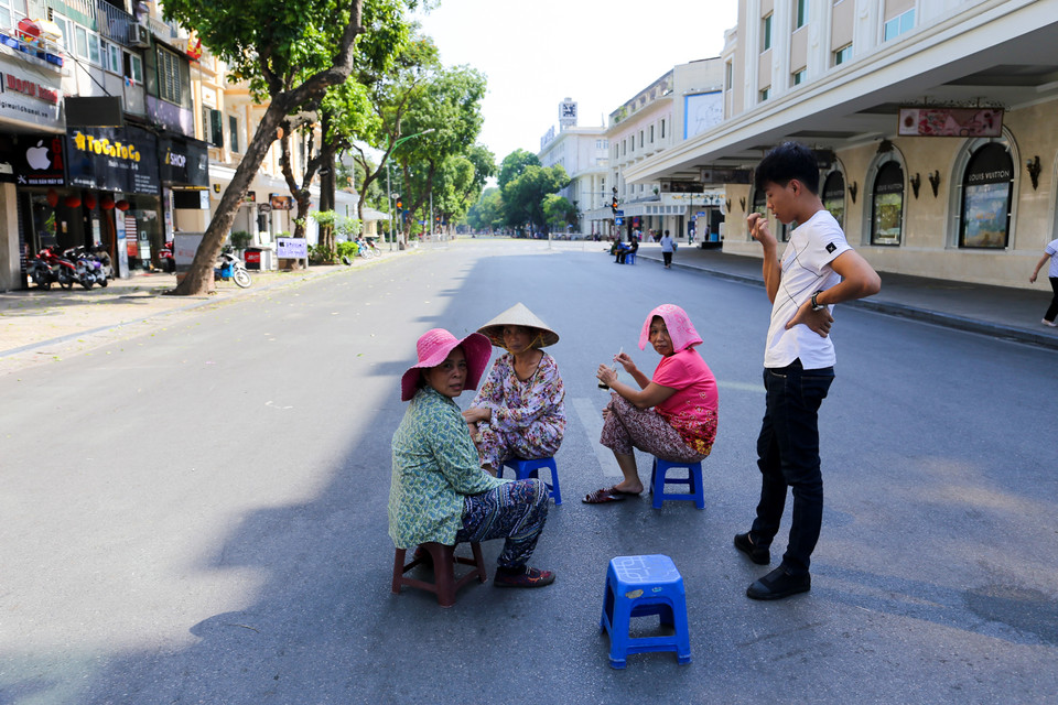 Quá vắng vẻ, nhiều người dân thậm chí còn mang ghế ra giữa đường ngồi vì chẳng có ai qua lại. (Ảnh: PV/Vietnam+)