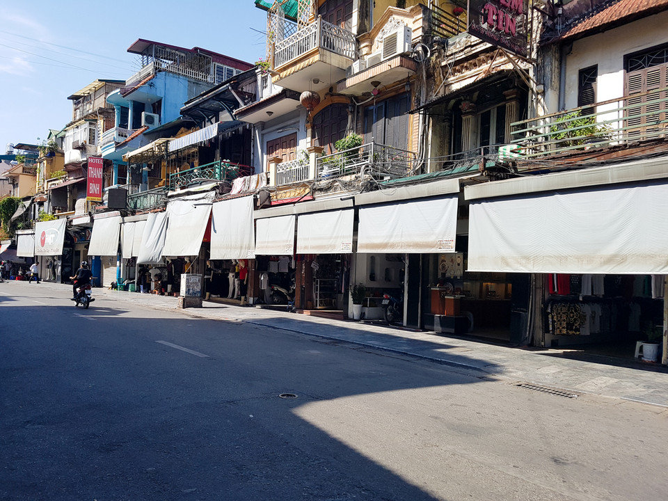 Nhiều hàng quán vắng khách, phủ bạt kín bưng. (Ảnh: PV/Vietnam+)