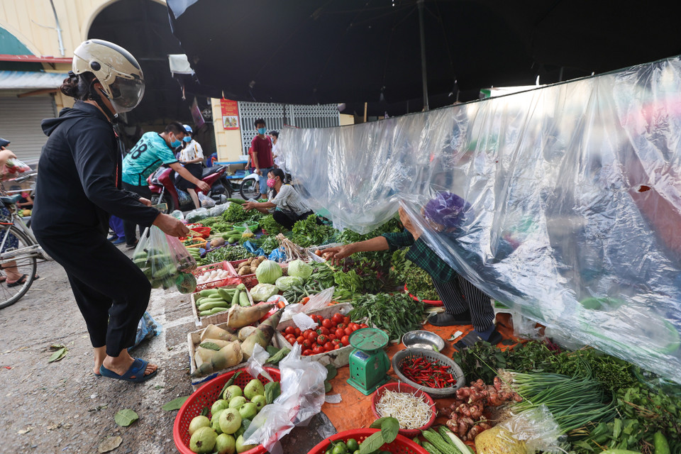 Trong khu vực chợ Phú Gia, các tiểu thương phải lắp màn chắn bằng nilon để giữ khoảng cách với người dân. (Ảnh: Minh Sơn/Vietnam+)