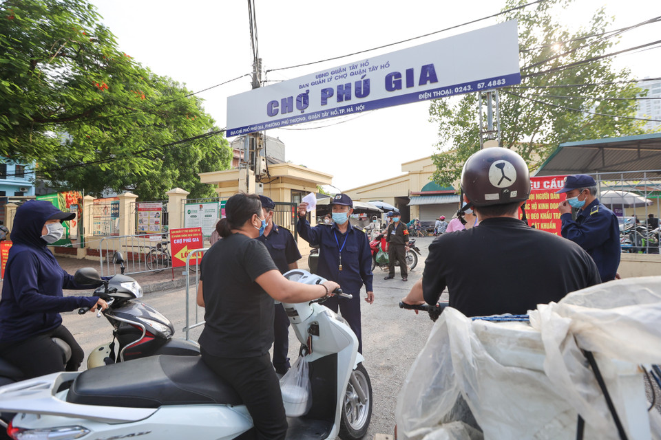 Tại khu vực chợ Phú Gia (phường Phú Thượng, Tây Hồ), Uỷ ban Nhân dân phường đã đã bố trí các tổ lưu động, hướng dẫn người dân sử dụng thẻ để đi vào chợ đúng quy định. (Ảnh: Minh Sơn/Vietnam+)