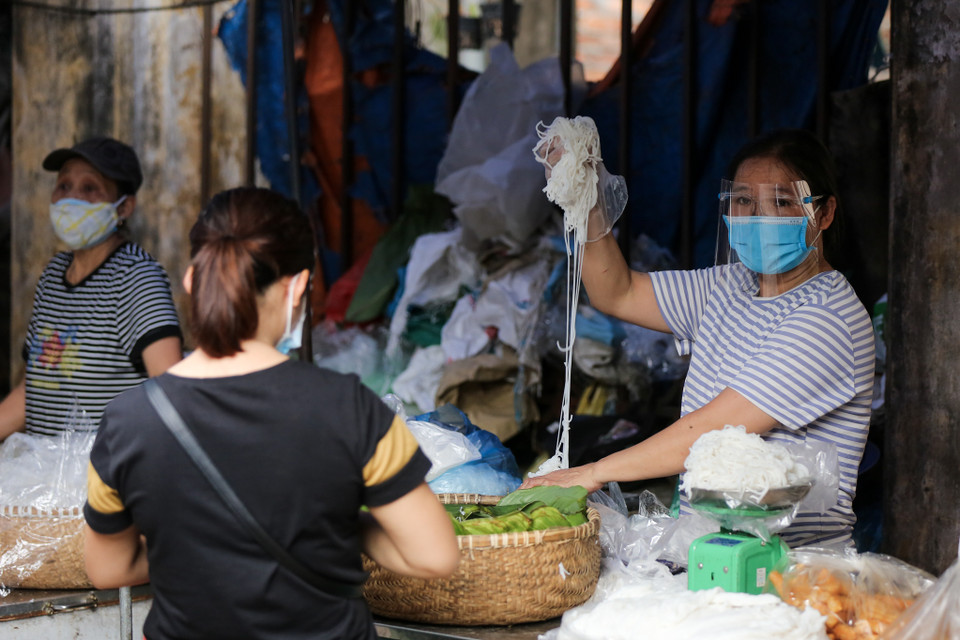 Những tiểu thương trong chợ cũng phải đảm bảo giữ khoảng cách an toàn với khách hàng đồng thời có những biện pháp phòng dịch phù hợp. (Ảnh: Minh Sơn/Vietnam+)