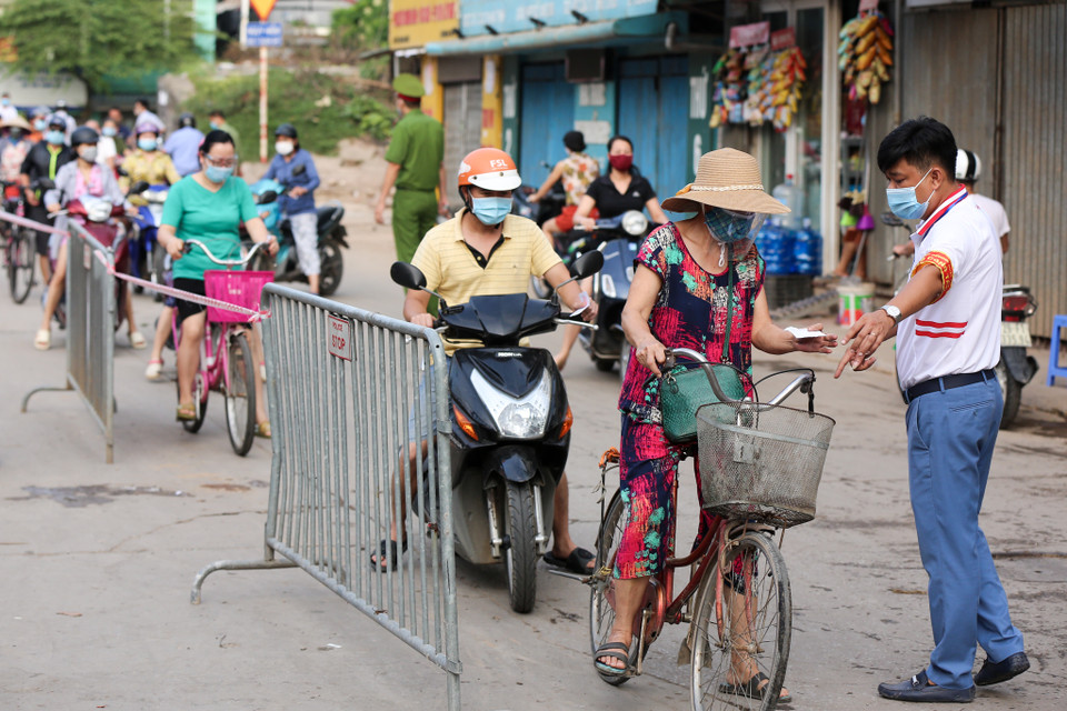 Ghi nhận tại chợ Nhật Tân trên địa bàn quận Tây Hồ, người dân được nhận 'thẻ đi chợ' và thực hiện nghiêm các quy định giãn cách trước khi vào mua sắm nhu yếu phẩm. (Ảnh: Minh Sơn/Vietnam+)