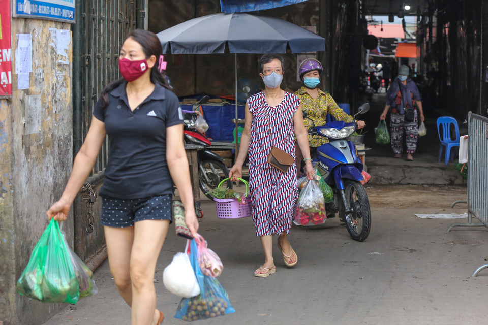 Người dân vào và đi ra khỏi chợ sẽ theo các hướng khác nhau nhằm đảm bảo khoảng cách an toàn. (Ảnh: Minh Sơn/Vietnam+)