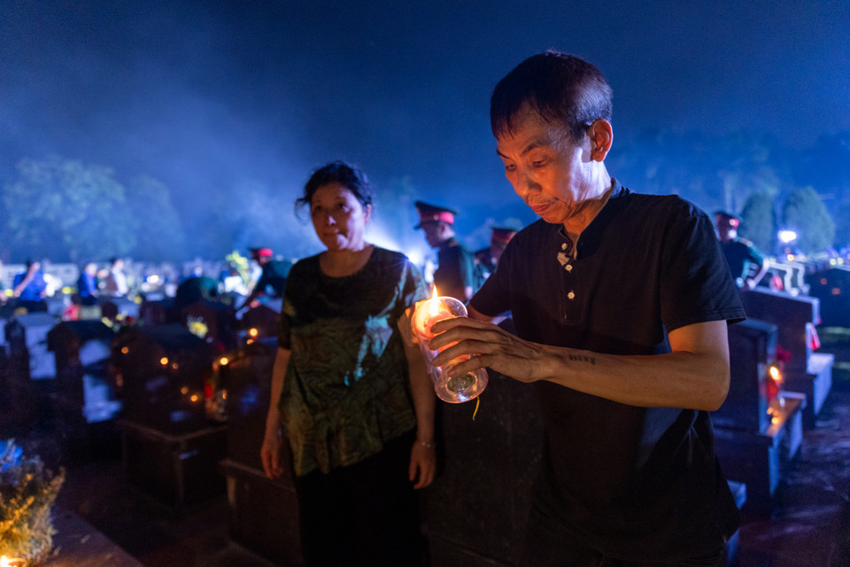 Hai vợ chồng cựu chiến binh Đinh Phú Ngọc viếng phần mộ người anh trai đã hy sinh năm 1972 tại Quảng Ngãi. Ông Ngọc nghẹn ngào, dù nhà trên phố cổ nhưng năm nào hai vợ chồng cũng xuống đây dịp này để thắp một nén nhang thơm cho anh. Nghĩa trang này cũng là nơi an nghỉ của 3 người bạn, người đồng đội khác của ông. (Ảnh: Minh Sơn/Vietnam+)