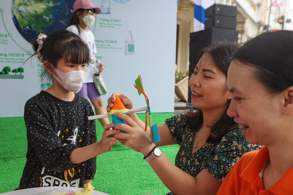 Các bậc phụ huynh cũng tham gia cùng các em nhỏ để chế tạo thành món đồ chơi bổ ích. (Ảnh: PV/Vietnam+)