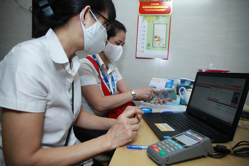Để việc chi trả lương diễn ra an toàn, thuận lợi, thời gian qua, Bảo hiểm xã hội Thành phố Hà Nội đã phối hợp với Bưu điện Thành phố và các địa phương thường xuyên tuyên truyền về thời gian, phương thức nhận lương hưu, trợ cấp bảo hiểm xã hội tại nhà trong thời gian phòng, chống dịch COVID-19. (Ảnh: PV/Vietnam+)