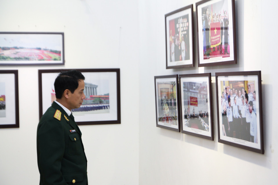 Một quân nhân trầm ngâm bên các hình ảnh. (Ảnh Minh Sơn/Vietnam+)