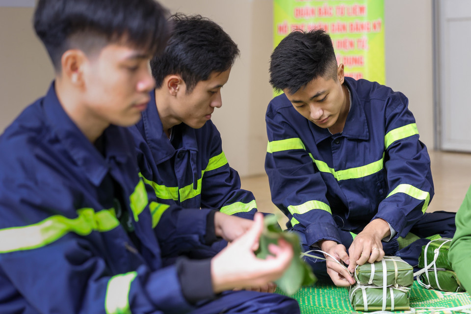  Những đôi bàn tay đã quen cầm vòi cứu hỏa giờ đây cũng khéo léo với từng công đoạn gói bánh chưng. (Ảnh: Minh Sơn/Vietnam+)