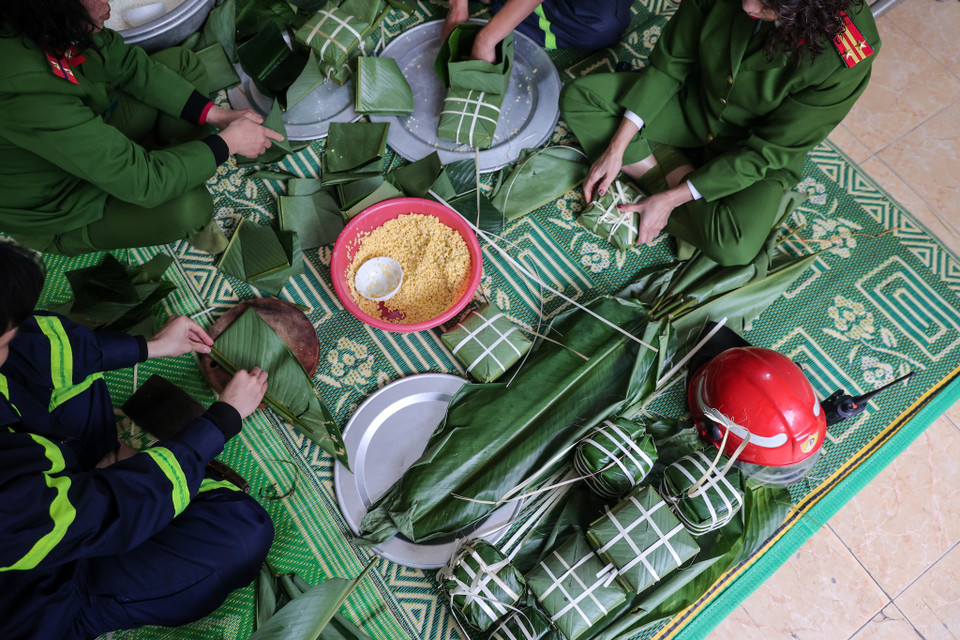 Đây cũng là dịp để các anh em đi trước hướng dẫn cho các chiến sỹ trẻ kinh nghiệm gói bánh chưng ngày Tết. (Ảnh: Minh Sơn/Vietnam+)