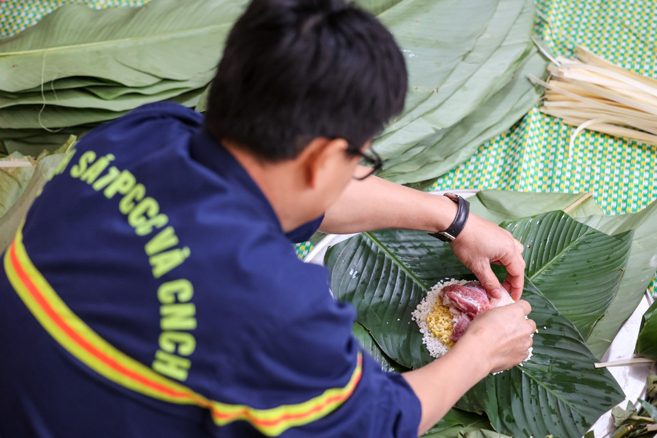 Theo Trung tá Khúc Nguyên Khánh, Phó Đội trưởng Đội Cảnh sát Phòng cháy chữa cháy và Cứu nạn cứu hộ quận Bắc Từ Liêm, gói bánh chưng là hoạt động thường niên của đơn vị mỗi khi Tết đến. Hoạt động này để chiến sỹ ở lại đơn vị trực Tết được hưởng không khí Tết ấm áp đồng thời gắn kết các thành viên với nhau. (Ảnh: Minh Sơn/Vietnam+)