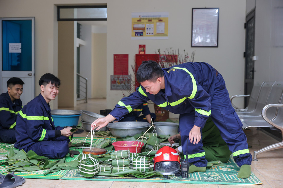 Mỗi khi 'xung trận' họ như những chiến binh khống chế 'giặc' lửa. Nhưng khi về với cuộc sống thường ngày, họ lại rất giản dị khi cùng nhau gói những chiếc bánh chưng để đón Tết tại đơn vị. (Ảnh: Minh Sơn/Vietnam+)