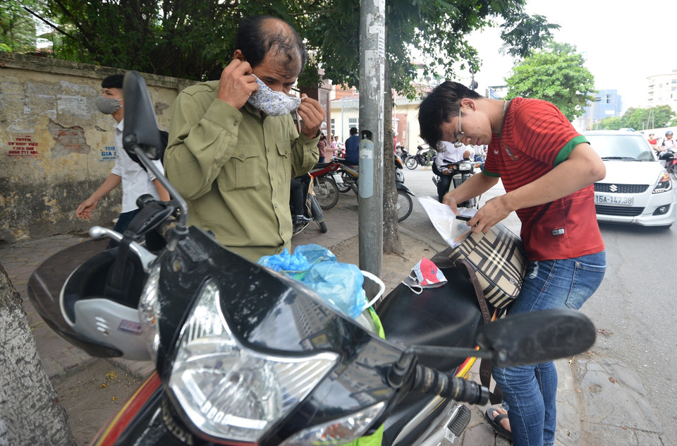 Sau 90 phút môn thi cuối cùng, rất nhiều phụ huynh đã thu dọn hành lý trước các điểm thi để chờ con em mình thi xong. (Ảnh: Minh Sơn/Vietnam+)